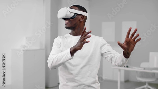 Fototapeta Portrait of African-American man in white clothes use augmented reality headset 