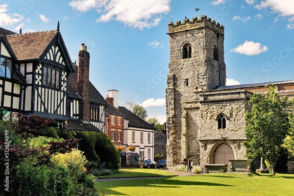 Fototapeta Holy Trinity Parish Church in the village of Much Wenlock, Shropshire, England. 16 C half-timbered Guildhall on left