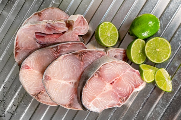 Fototapeta filetes de pescado fresco postas de bagre con limones