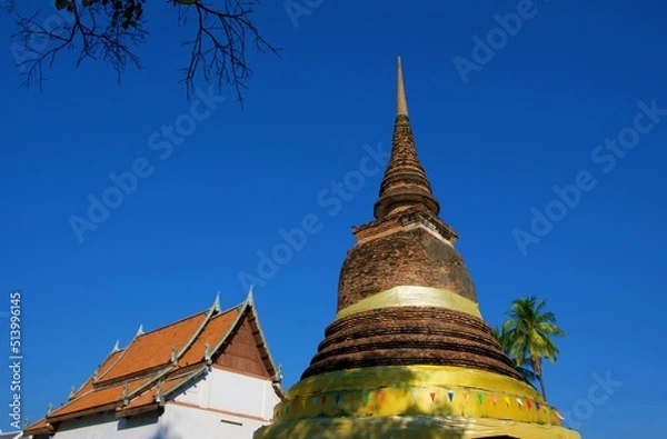 Fototapeta Chedi in Traphang Thong Temple Sukhothai Province, Thailand, with a white viharn in the background.