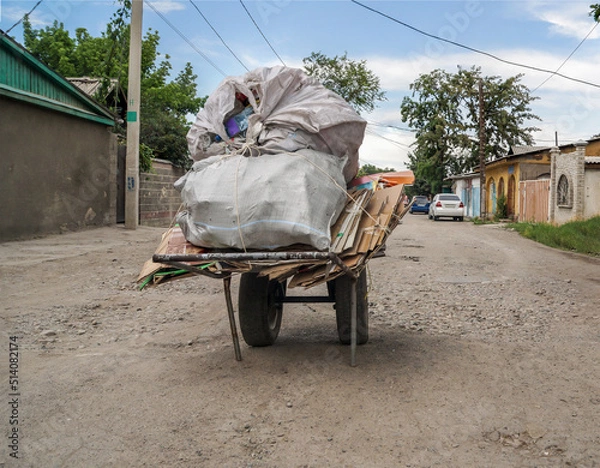 Fototapeta A cart with a load in the middle of the street.