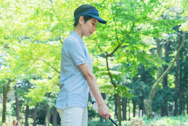 Fototapeta スイングするゴルフウェアを着た日本人女性