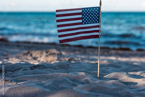 Fototapeta There is an American flag on the beach on the sand. A symbol of freedom. Patriotism. July 4th Holiday. Soft focus