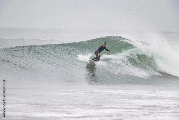 Fototapeta 湘南の海でサーフィンを楽しむ男性