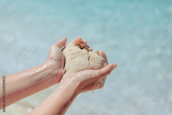 Fototapeta woman holding sand making heart shape sea beach on background