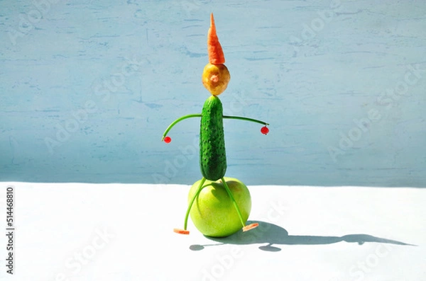 Obraz Vegetable figurine: cucumber, potato, carrot, parsley stalks, currant berries, apple. Summer healthy food concept.