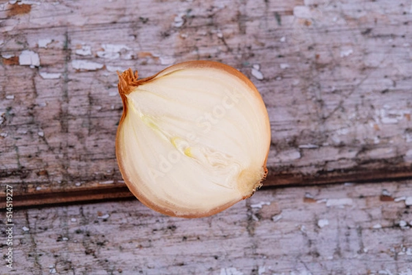 Fototapeta A halved onion on a wooden surface background.