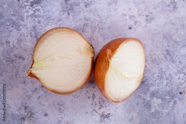 Fototapeta A halved onion on a marble surface background.