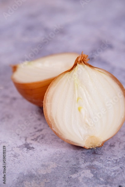 Fototapeta A halved onion on a marble surface background.