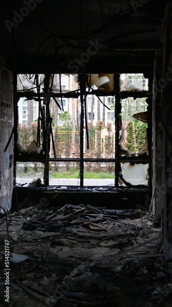 Fototapeta Irpin, Ukraine - May 22, 2022: view from the broken window of a burned room of a house bombed by the Russian army
