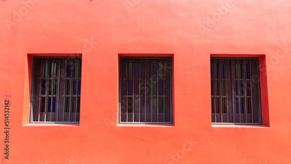 Fototapeta Three windows on a red wall.