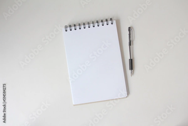 Fototapeta blank notebook at the white desk. Flat lay top view.