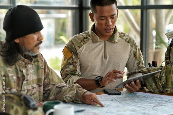 Fototapeta army ranger special force discussion looking pointing at the war map on table and GPS to mark up location plan before attact enemy

