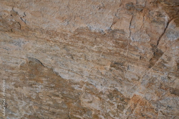 Fototapeta Rough texture of fine natural stone, photographed during golden hour, selective focus