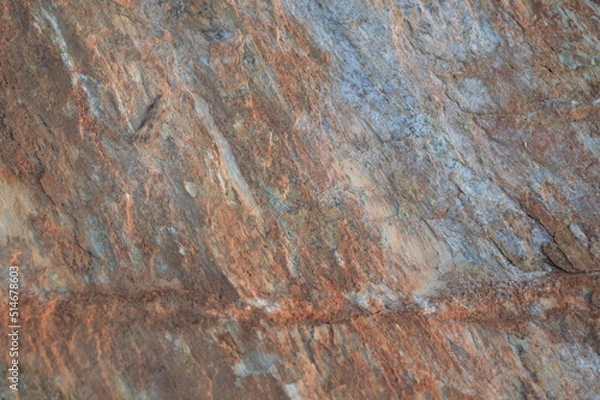 Fototapeta Rough texture of fine natural stone, photographed during golden hour, selective focus