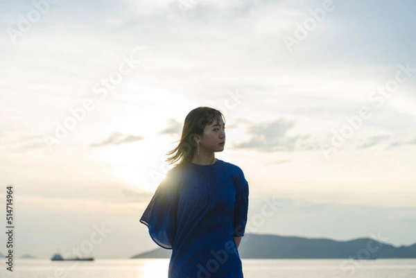 Fototapeta 夕暮れの海にいる女性