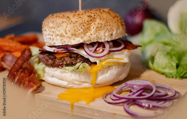 Obraz Burger w artystycznej kompozycji z frytkami i batatami oraz cebulą pieczarkami. Burgerownia - zdjęcie świeżego, apetycznego burgera