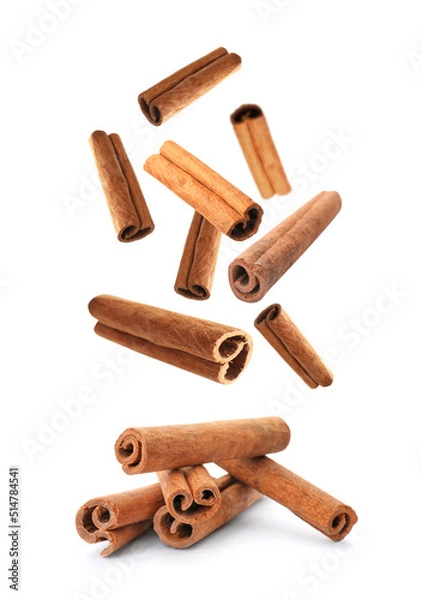 Obraz Aromatic cinnamon sticks falling on white background