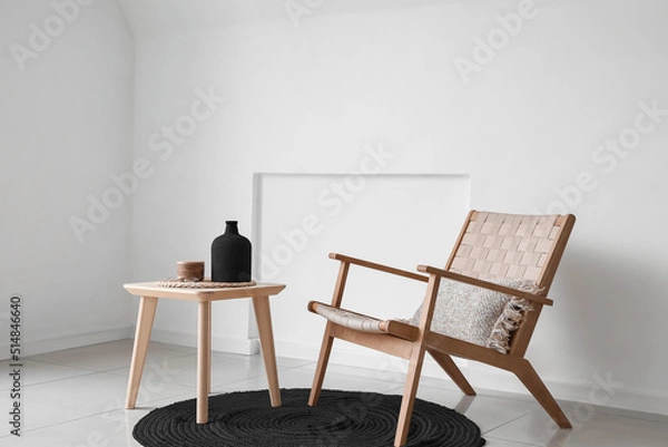 Fototapeta Modern table and armchair with black rug in interior of light room