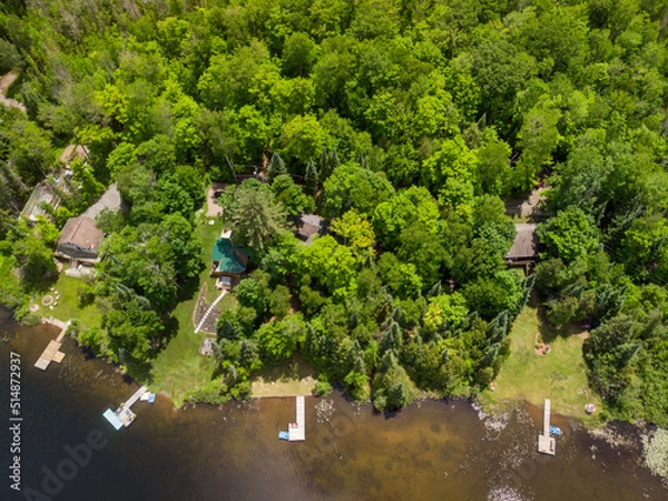 Fototapeta An aerial view looking down on several cottages and their swim docks.