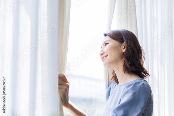 Fototapeta カーテンを開ける女性