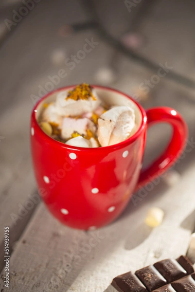 Obraz Hot chocolate with marshmallow in red dotted mug on a wooden table. Cosy winter evening winter composition christmas time