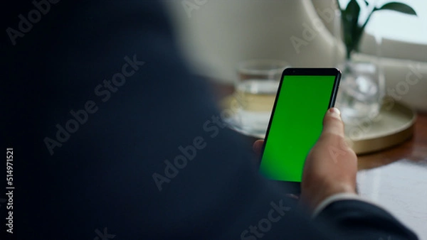 Fototapeta Closeup man use chroma key smartphone. Businessman hand touch green screen phone