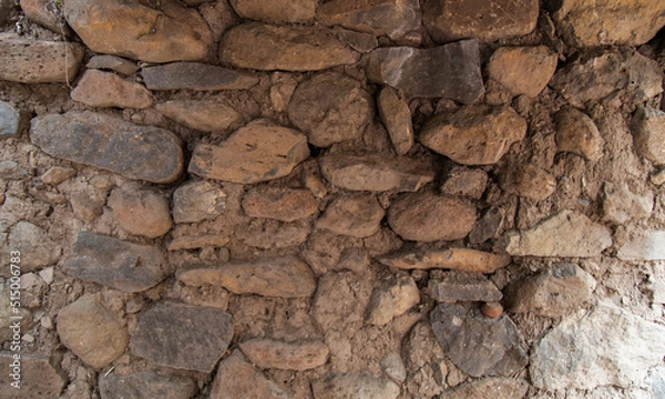 Obraz Rock or stone wall bricks pasted with mud. Wall texture and background.
