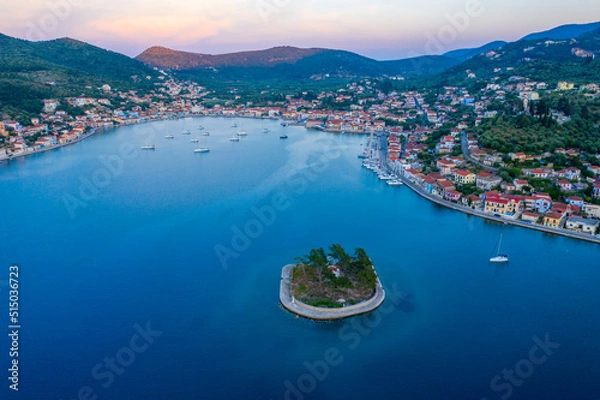 Fototapeta Vathy harbor with sailboats and catamarans anchored on the shore of the village of Ithaca Greece. Small marina Limani Vathy with a small island at the entrance. Sunset over the harbour. Beautiful Sea 