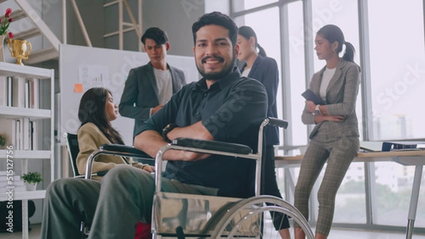 Fototapeta A disabled company employee is able to work happily with colleagues in the office.