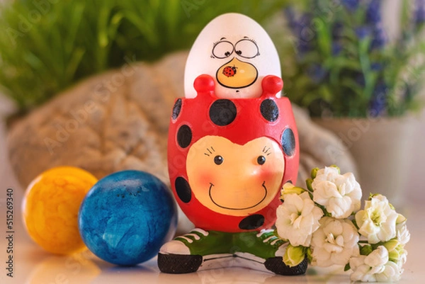 Fototapeta Colourful Easter eggs and a funny ladybird egg cup