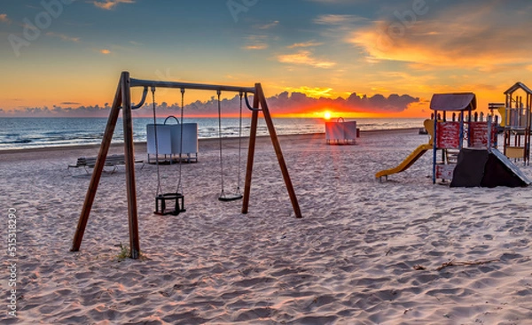 Fototapeta Playground of children on the sandy shore of the Baltic Sea at dawn