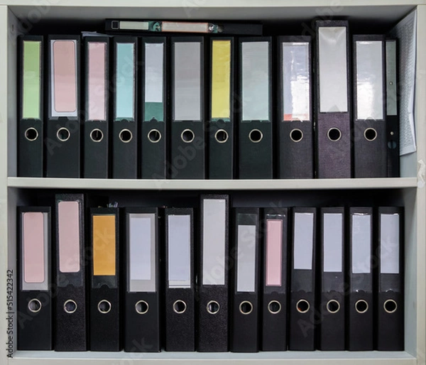 Fototapeta Closeup of the black plastic folder are rowing in the white shelf.