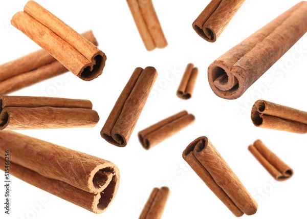 Obraz Aromatic cinnamon sticks falling on white background