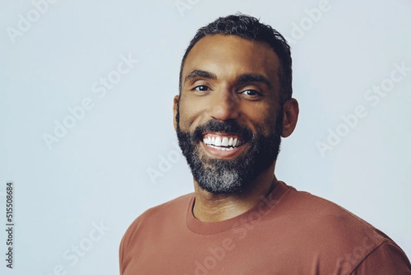 Obraz headshot portrait of a handsome smiling bearded mid adult man looking at camera against gray background studio shot