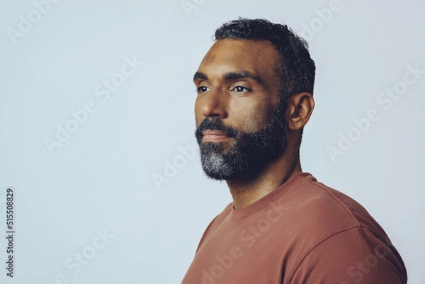 Obraz headshot portrait of a handsome bearded mid adult man looking away at copy space against gray background studio shot
