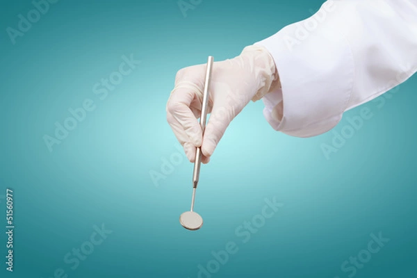 Fototapeta Closeup of dentist hand taking mirror from on of dental tools.