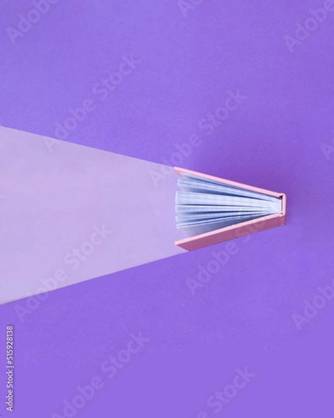 Fototapeta Creative education concept. Minimal composition with book on pastel purple background. Back to school idea. Knowledge and light inspiration.