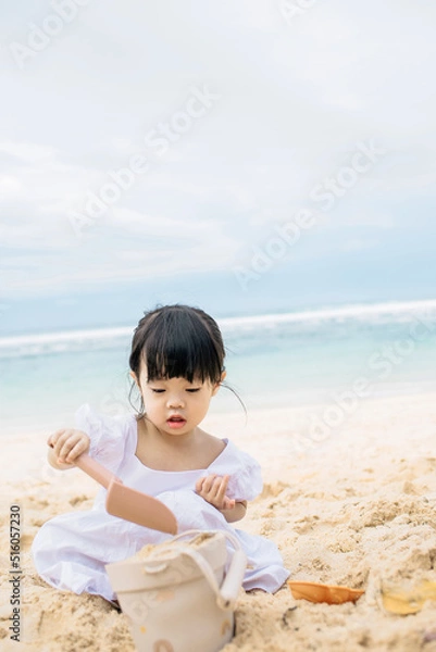 Obraz a child is playing sands by the sea on the beach