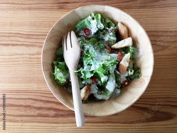 Obraz Fresh tomatoes with cucumber, lettuce, red onion and spices in a white bowl. 