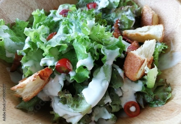 Obraz Fresh tomatoes with cucumber, lettuce, red onion and spices in a white bowl. 