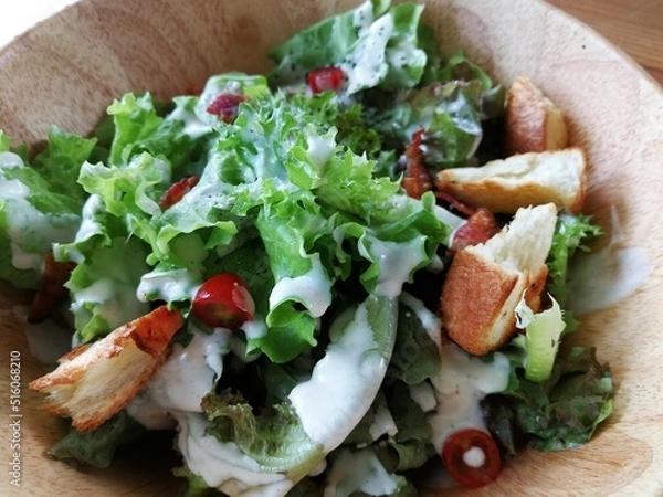 Obraz Fresh tomatoes with cucumber, lettuce, red onion and spices in a white bowl. 