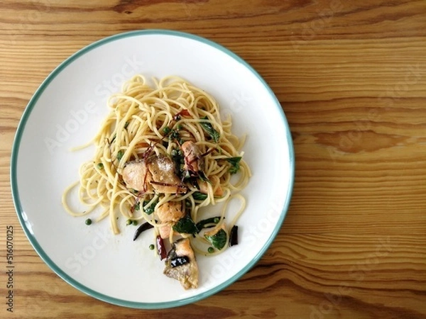 Obraz Spaghetti on black plate on wooden background. top view.