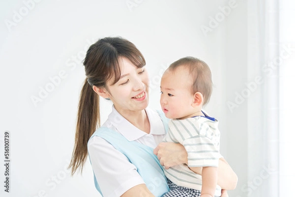 Fototapeta 赤ちゃんを抱っこする保育士