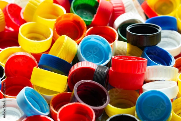 Fototapeta Caps from plastic bottles. Lots of colorful plastic bottle caps. Product of the chemical industry. Threat to the environment. Plastic pollution. Ecological problems. Recycle materials in production