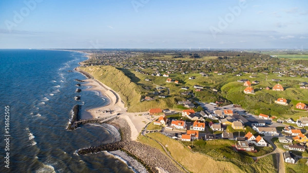 Fototapeta Aerial view of the scenic coast line of Denmark with the idyllic village of Lonstrup sitting on the dunes and rocks