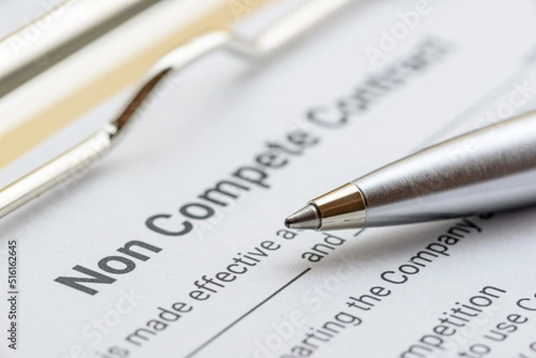 Fototapeta Blue pen on a non compete contract. Noncompete contract is an agreement between employee and employer, not to enter into competition in subsequence business effort. Legal concept.