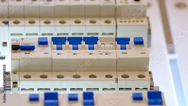 Fototapeta Fuse box panels with blue circuit breakers. Collection of electrical equipment.