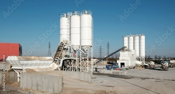 Fototapeta Scenery of concrete factory with white silos for production of concrete