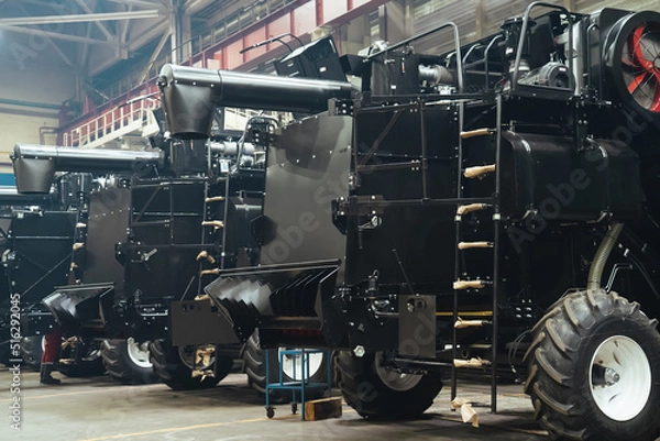 Obraz Factory hangar with combine harvesters assembled. Industrial production of agricultural machinery.